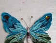 V quilling tehniki narejen metulj v modro in zelenih barvah