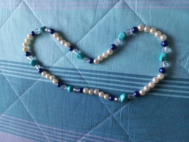 colana - Ogrlica z belimi perlami, vmes so temno modre perle in kamen tirkizne barve