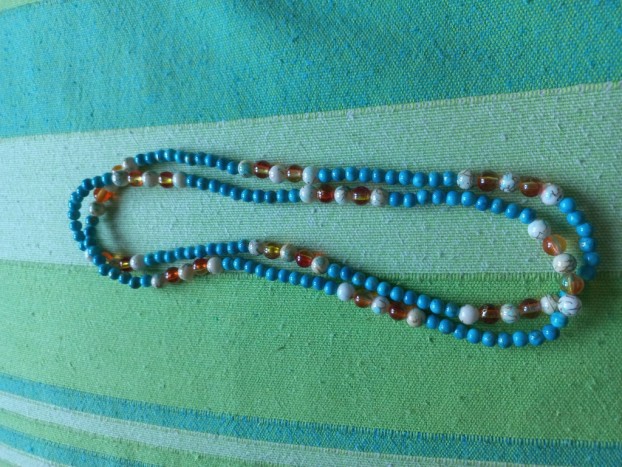 Daljša ogrlica - Ogrlica daljše dolžine, da se lahko 2x ovije okoli vsatu. Kombinacija tirkiznih perlic in belih in oranžnih perlic